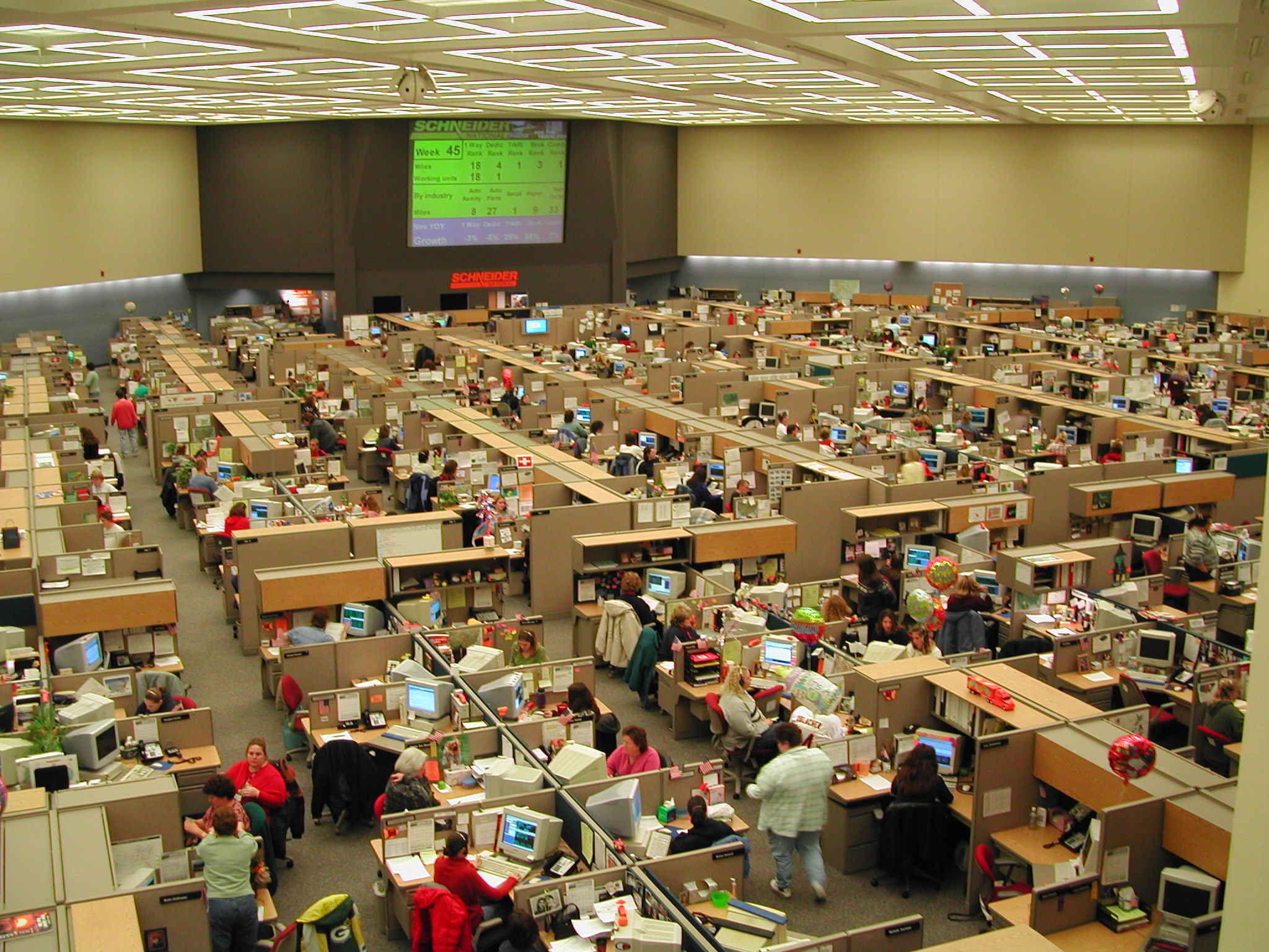 Photograph of the Schneider National dispatch center — rows of dispatchers at desks with monitors
